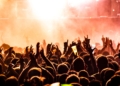 people raising their hands on concert